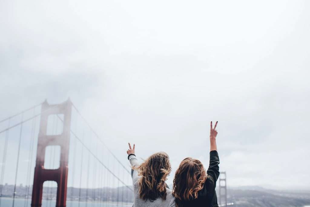 travel buddy, peace sign with golden gate bridge in view.